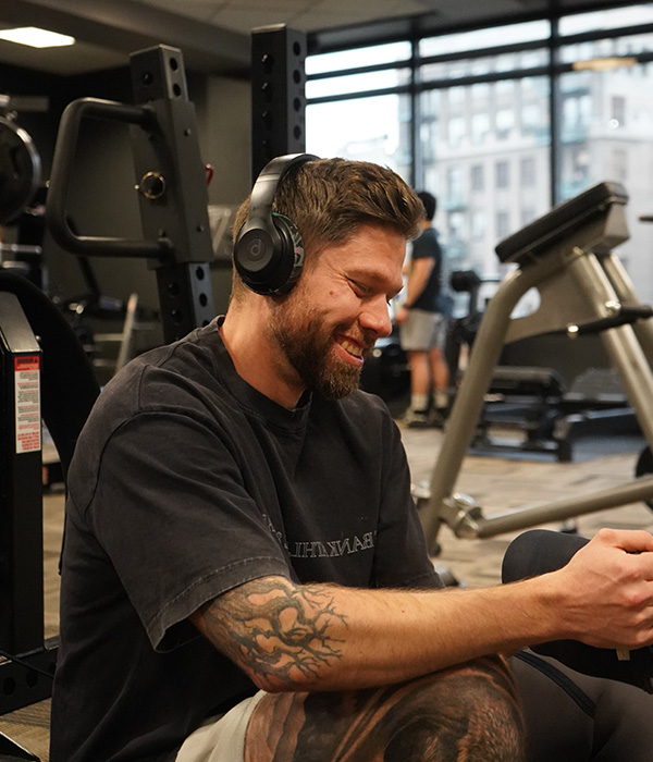 Young man training at gym listening to music